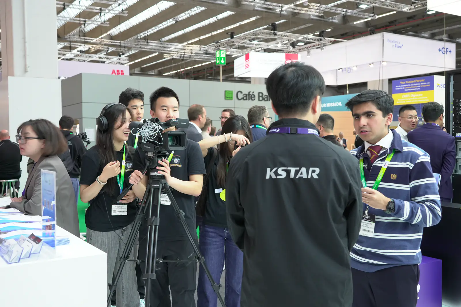 FIS Media Club students filming an interview with a tripod-mounted camera at the Frankfurt Tech Show